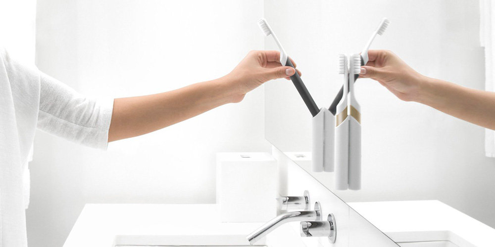 clean white bathroom with woman grabbing a toothbrush