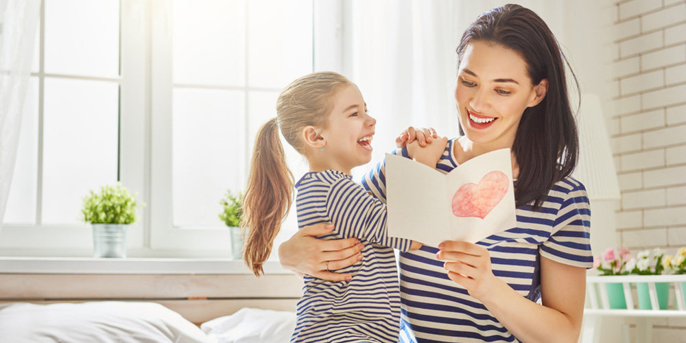daughter giving her mom a card