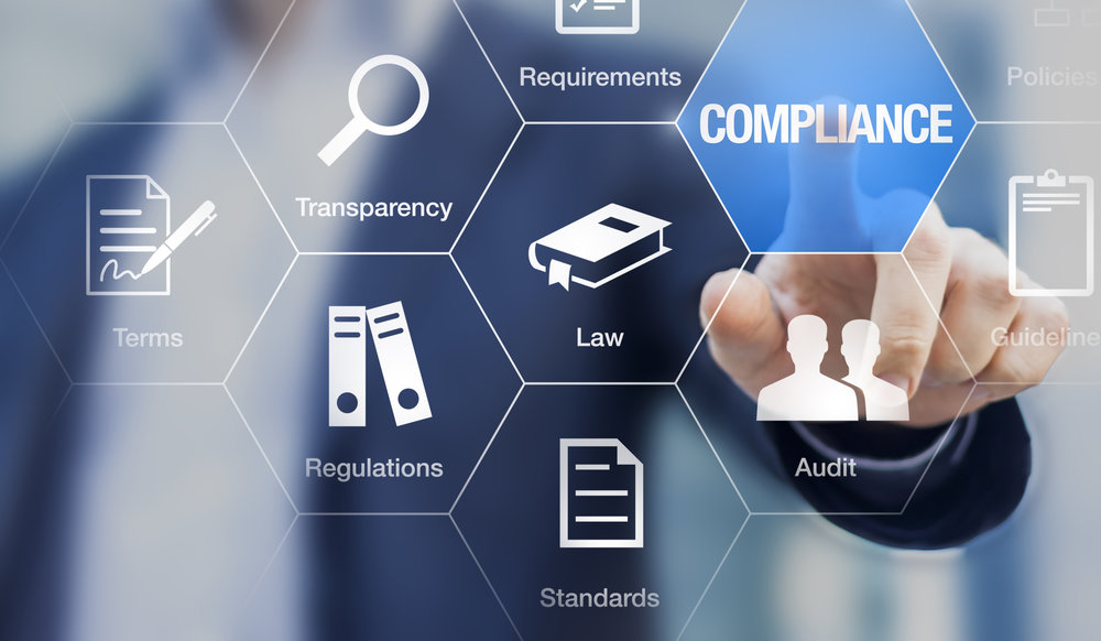 man touching the compliance word on a screen