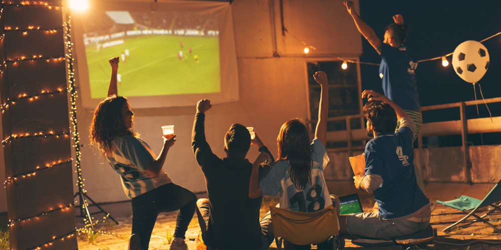 people watching a soccer game on a rooftop