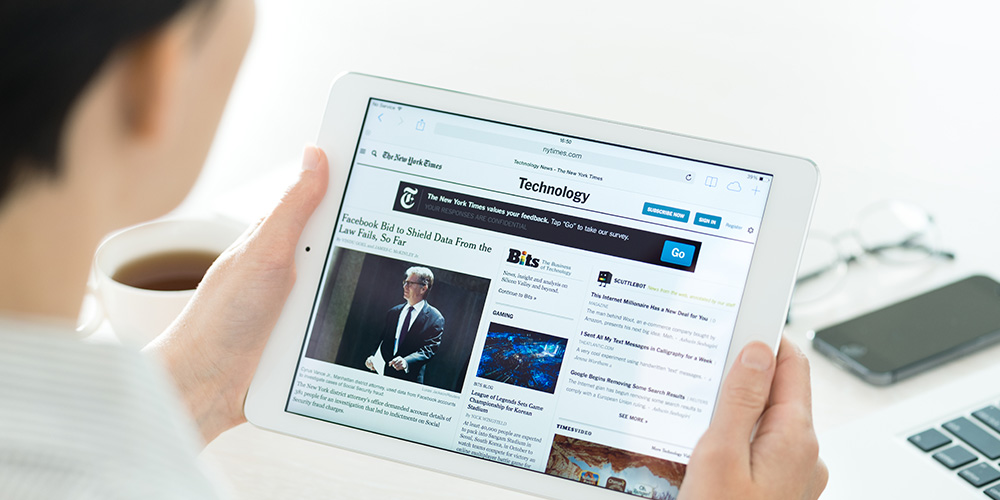 woman reading a news article on her tablet